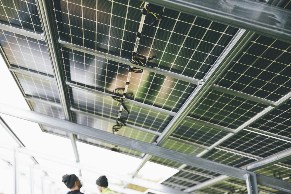 Close-up of solar panels being installed outdoors with technicians visible.